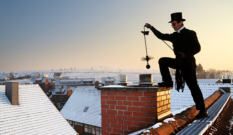 chimney sweep with stovepipe hat upon the roof